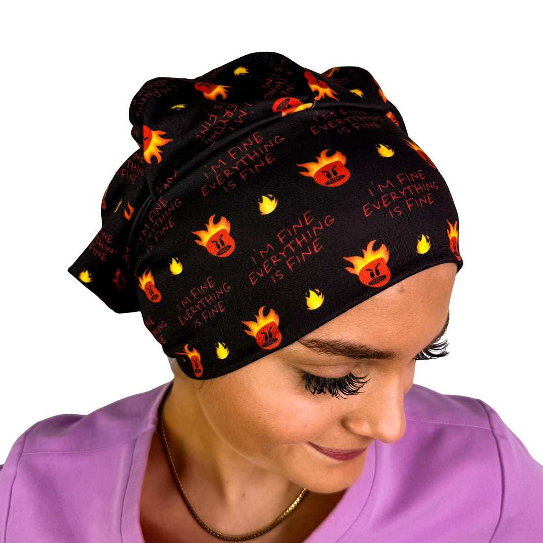 A woman wearing a black scrub cap with a repeating pattern of orange and yellow flames and the text &